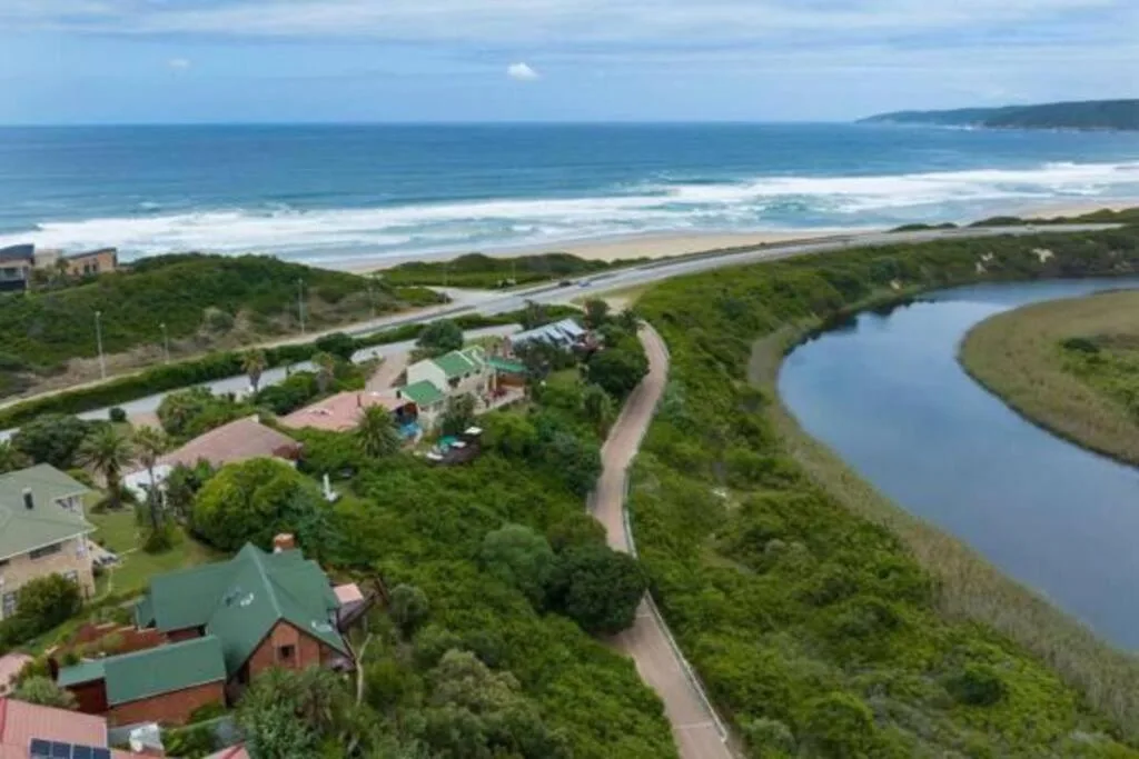 Aerial view of property with ocean, lagoon, and surrounding landscape