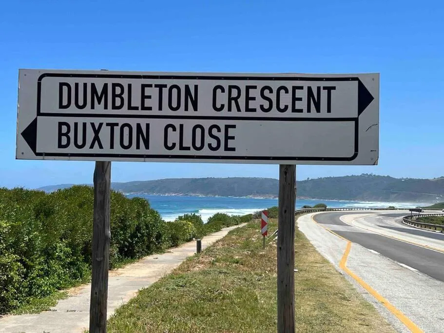 Coastal road sign overlooking pristine beach and turquoise ocean waters
