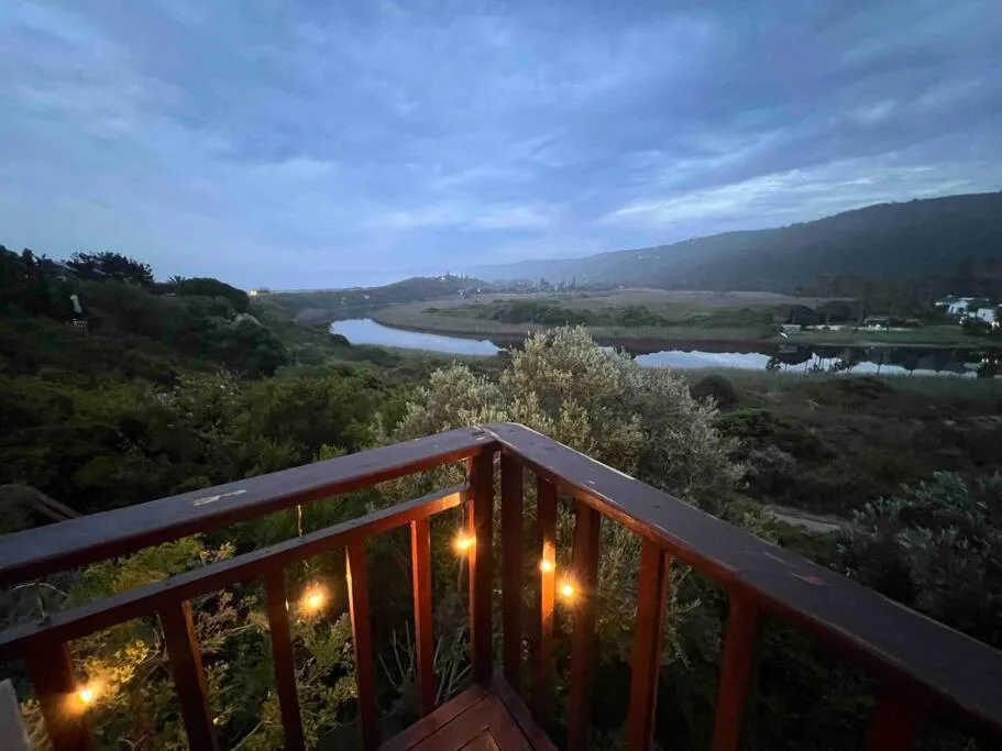 Twilight view of lagoon and mountains from illuminated wooden deck