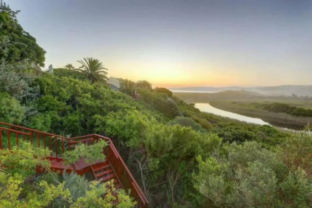 Scenic sunset vista over river valley and lagoon from hillside deck