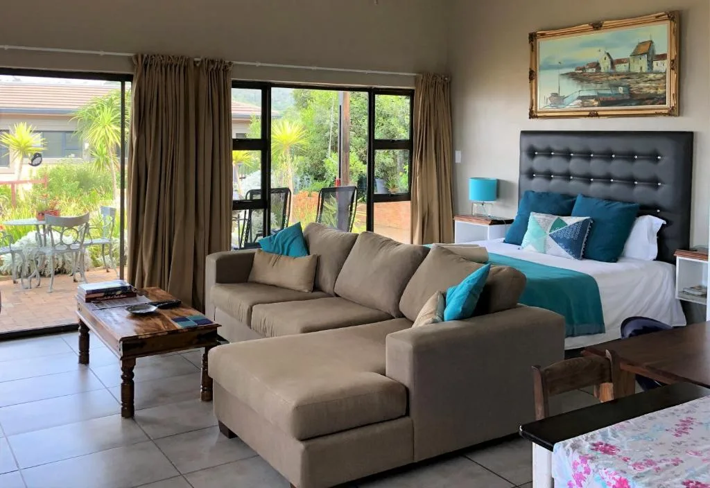 Spacious bedroom with queen bed, lounge seating area, and garden views