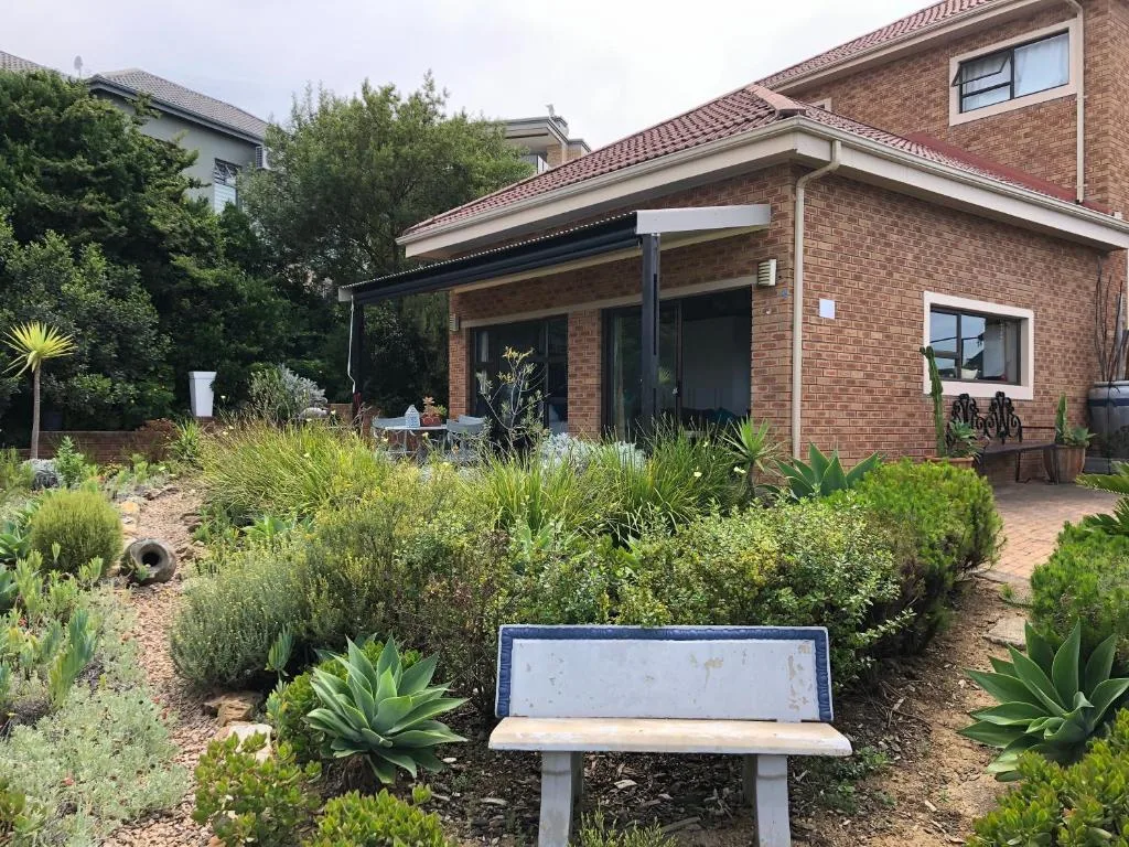 Modern brick cottage with covered patio and native garden plantings