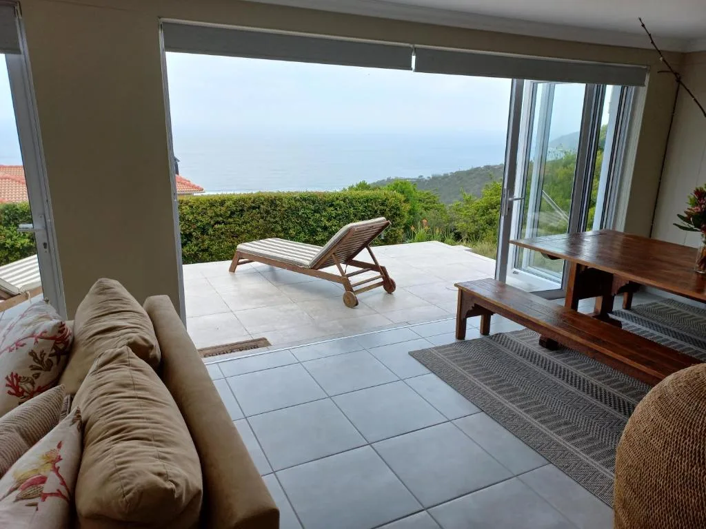 Spacious patio with lounger chairs overlooking coastal garden views