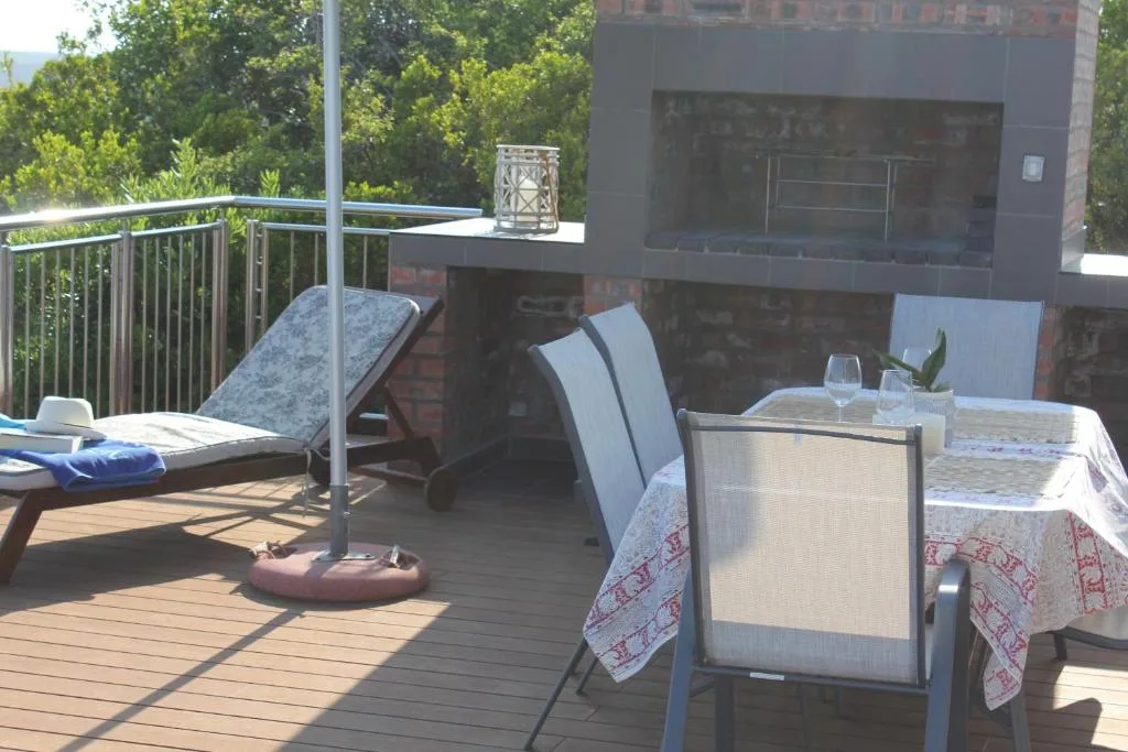 Spacious wooden deck with lounge chairs, dining table, and mountain views