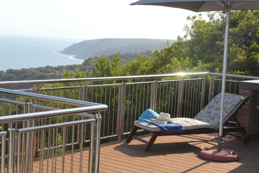 Wooden deck with lounger overlooking coastal cliffs and ocean views