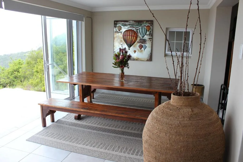 Wooden dining table with bench seating and mountain view through glass doors